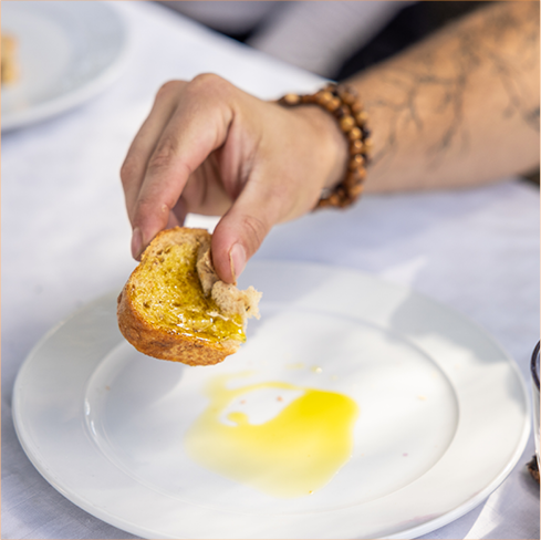 Man dipping bread in olive oil