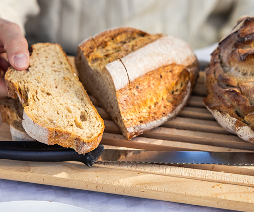 Hand breaking bread close-up